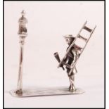 A sterling figurine depicting a lamplighter holder