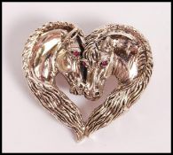 A stamped 925 silver heart shaped brooch in the fo