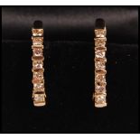 A pair of 14ct gold hoop earrings channel set with