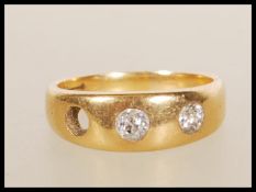 A stamped 18ct gold gypsy ring set with two round