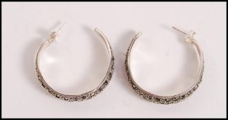 A pair of stamped 925 silver hoop earrings set wit