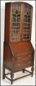 An early 20th Century oak bureau bookcase, leaded glass panel doors with adjustable shelves to the