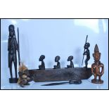 An Ibeji carved wooden figure relating to the Yoruba tribe decorated with a bead necklace and