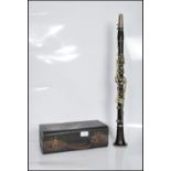 An early 20th Century cased rosewood five piece clarinet, set with nickel buttons and impressed