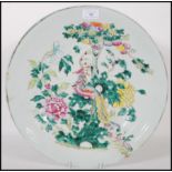 A large 19th Century Chinese Canton wall charger plate of round form having a celadon ground,