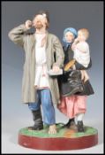 A 19th Century Russian Gardner bisque figurine group depicting a man with one boot and a bottle in