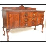 A 1920's mahogany bow front sideboard dresser in the Queen Anne style. Raised on ball and claw