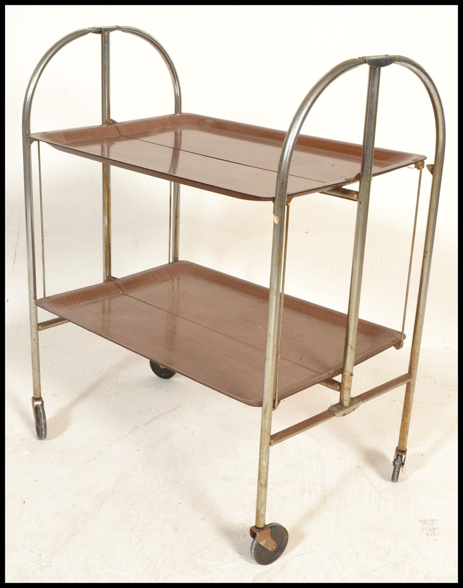 A retro mid century Gerlinol Brenshey Dinett retro chrome folding tea trolley being raised on