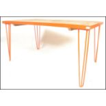 A retro style metal framed plank top refectory dining table raised on hairpin upright supports in