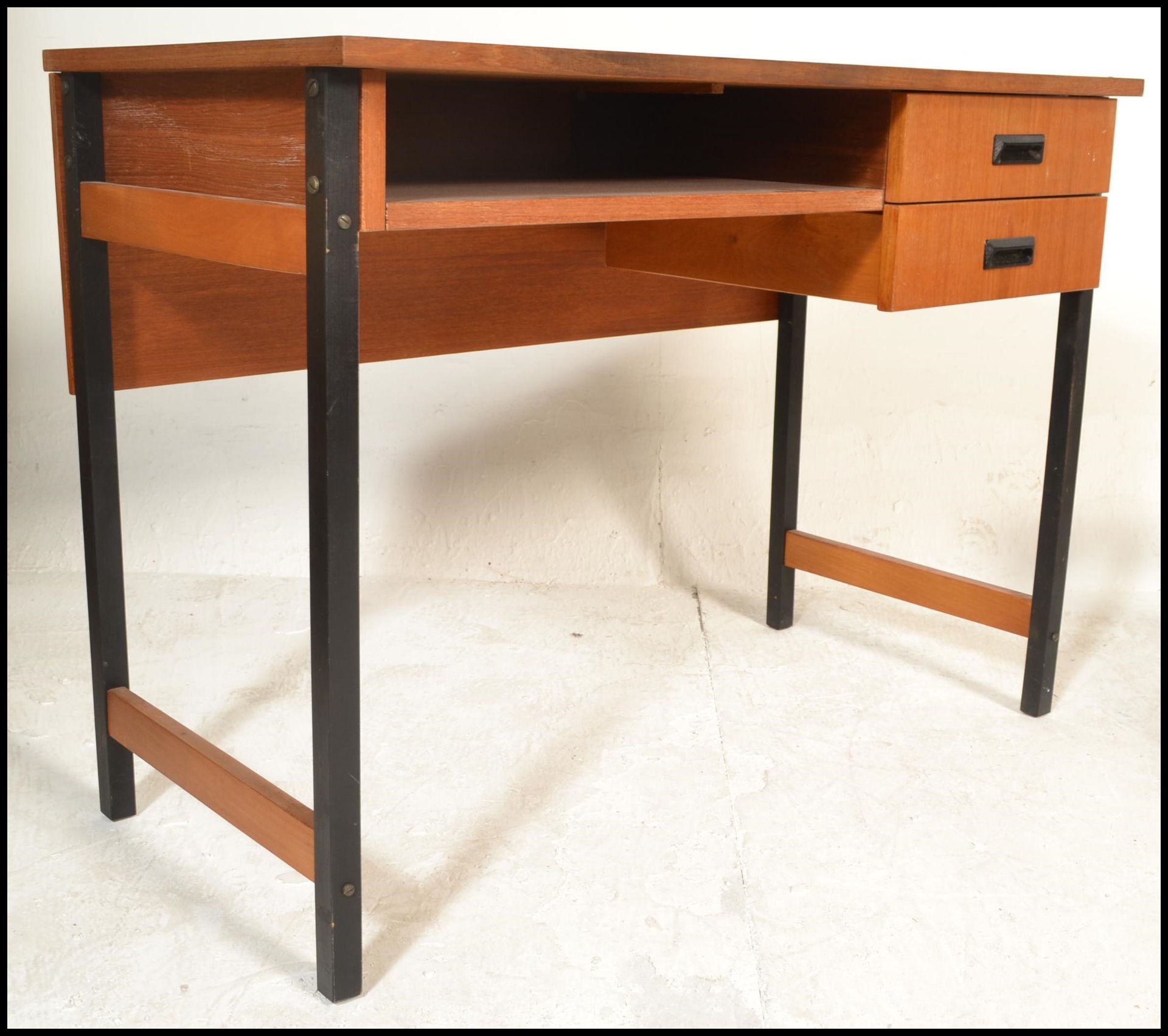 A 20th Century retro teak wood desk, raised on tubular black metal supports, two drawers to the