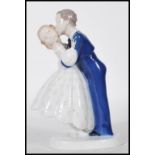 A B & G Danish porcelain figurine of a husband and wife kissing on round base. Marked B&G Denmark to