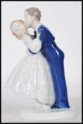 A B & G Danish porcelain figurine of a husband and wife kissing on round base. Marked B&G Denmark to