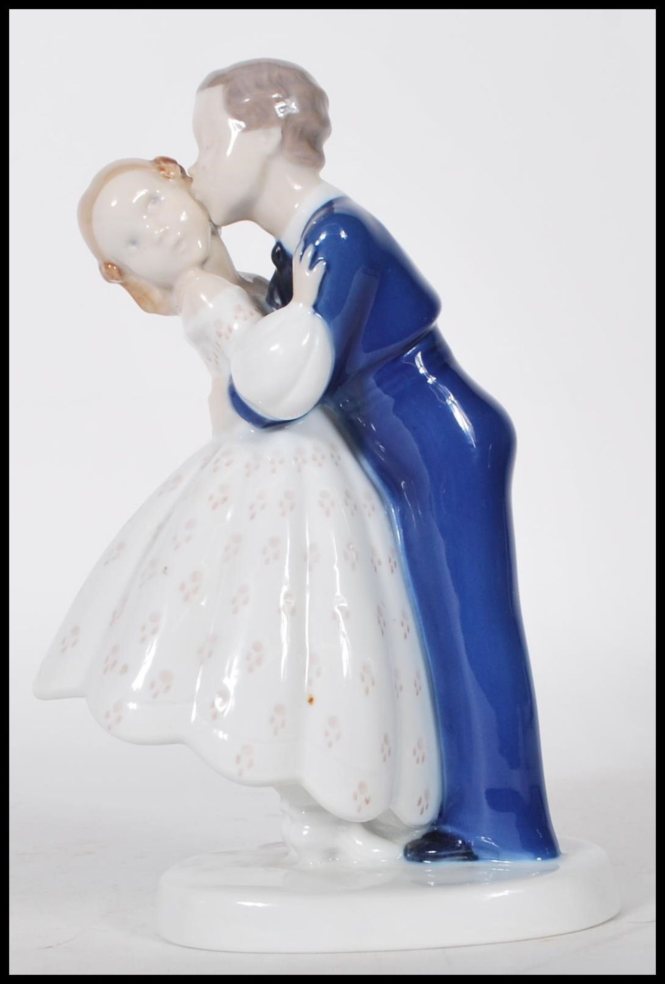 A B & G Danish porcelain figurine of a husband and wife kissing on round base. Marked B&G Denmark to