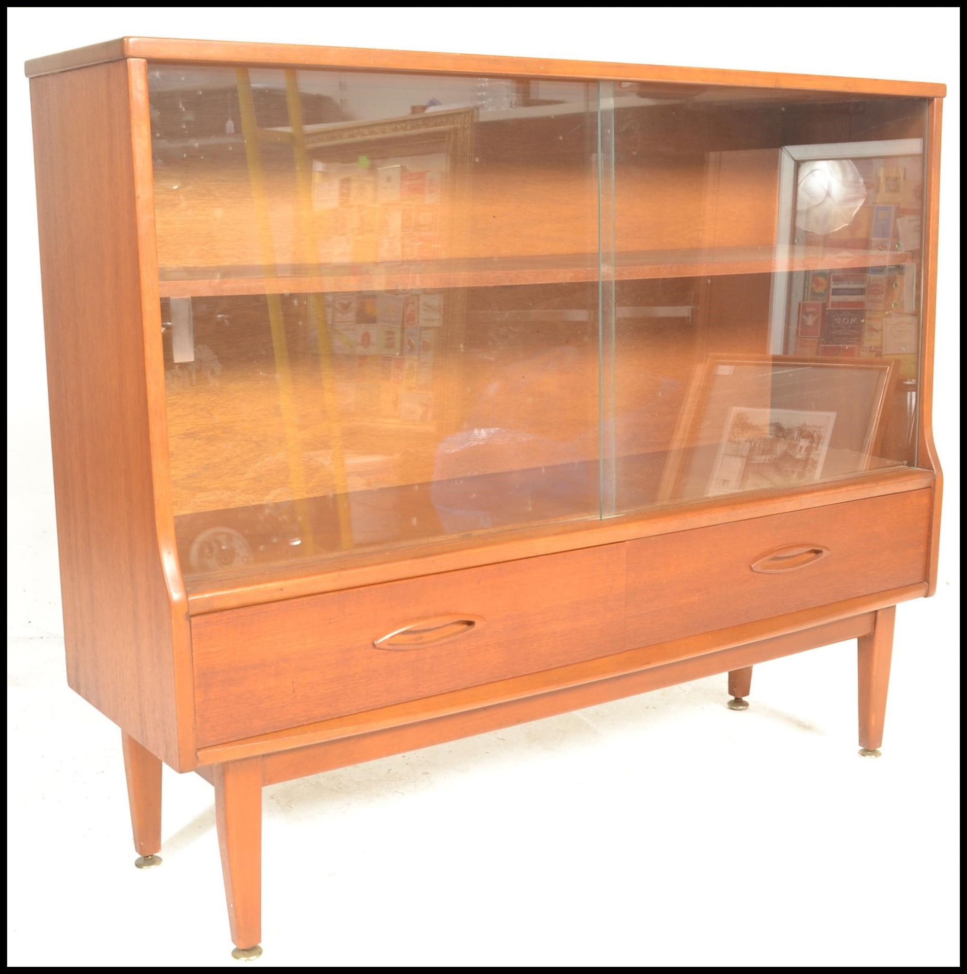 A retro 20th Century teak wood display cabinet having twin glass sliding doors with a shelved