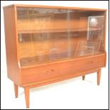 A retro 20th Century teak wood display cabinet having twin glass sliding doors with a shelved