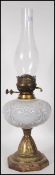 A Victorian 19th century oil lamp having a central white glass reservoir and glass flue all raised