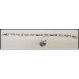 A silver linked bracelet having engraved scroll design to each link with a heart shaped clasp set