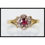 A hallmarked 18ct yellow gold ladies dress ring set with a round cut garnet with a halo of