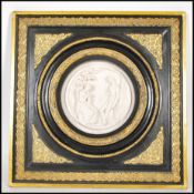 A 20th century gilt and ebony framed wall plaque being cast in relief depicting a classical courting