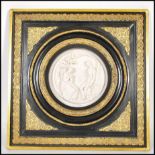 A 20th century gilt and ebony framed wall plaque being cast in relief depicting a classical courting