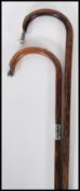 Two 20th Century walking stick canes with bamboo shafts and crook handles both terminating in silver