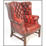 A 20th century Queen Anne style wing back Chesterfield chair having button back burgundy oxblood