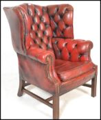 A 20th century Queen Anne style wing back Chesterfield chair having button back burgundy oxblood