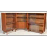 A set of three retro 20th Century teak wood glazed bookcases, each bookcase having sliding glass