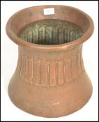 An early 20th Century Arts and Crafts hand worked copper planter on waisted cylindrical form, the