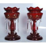 A pair of 19th Century Victorian ruby glass lustres, gilded decoration, on circular platform