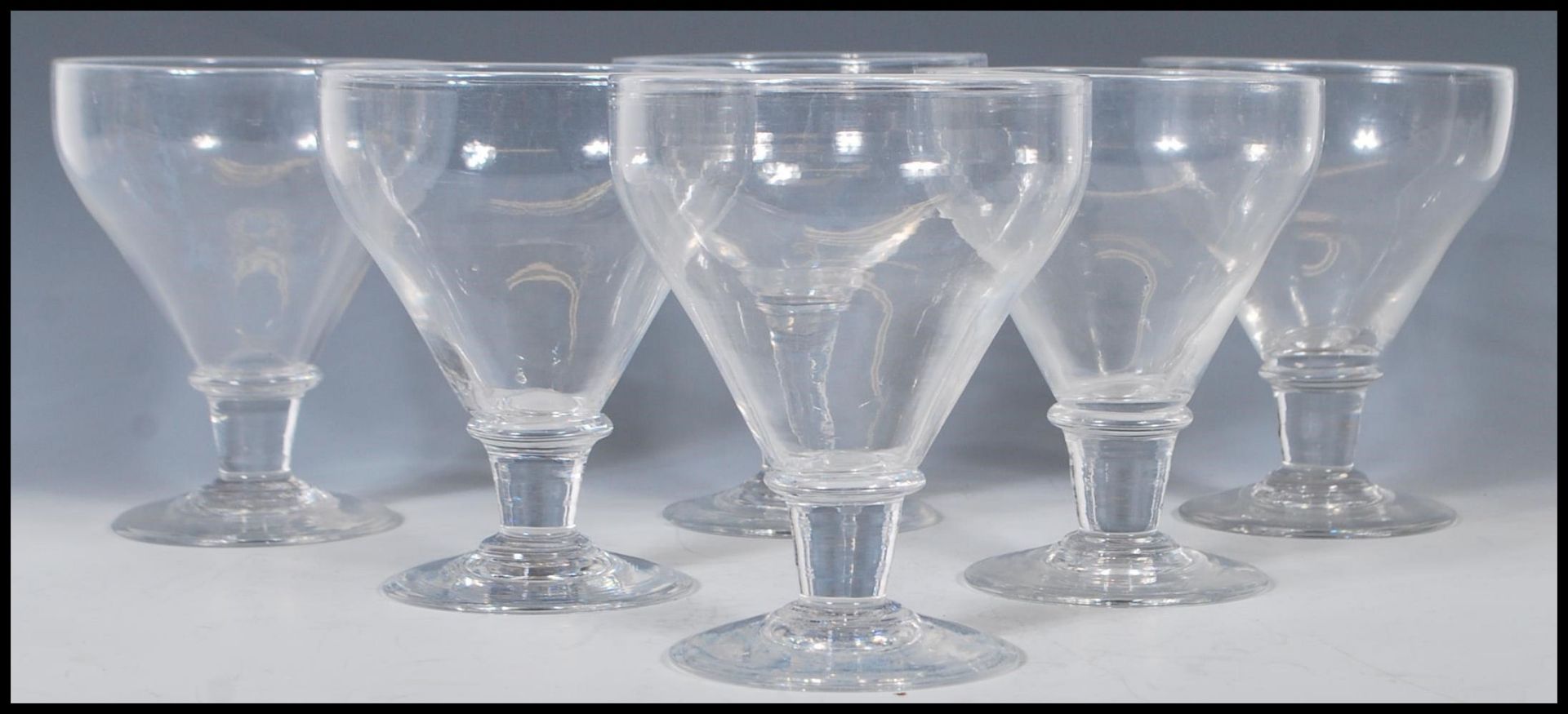 A group of six 19th Century Georgian rummer glasses having tapering bowls with capstan stems