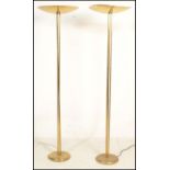 A pair of 20th Century Art Deco style standard floor lamp uplighters. Raised on a circular gilt base