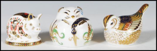 A group of three Crown Derby paperweights with gold stoppers to include a pig, a field mouse and a