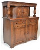 A 20th Century Jacobean revival oak court cupboard, moulded top, cup and cover carved supports,