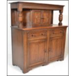 A 20th Century Jacobean revival oak court cupboard, moulded top, cup and cover carved supports,