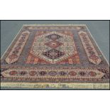 A large 20th Century Persian style woolen floor rug carpet on a neutral ground, polychrome central