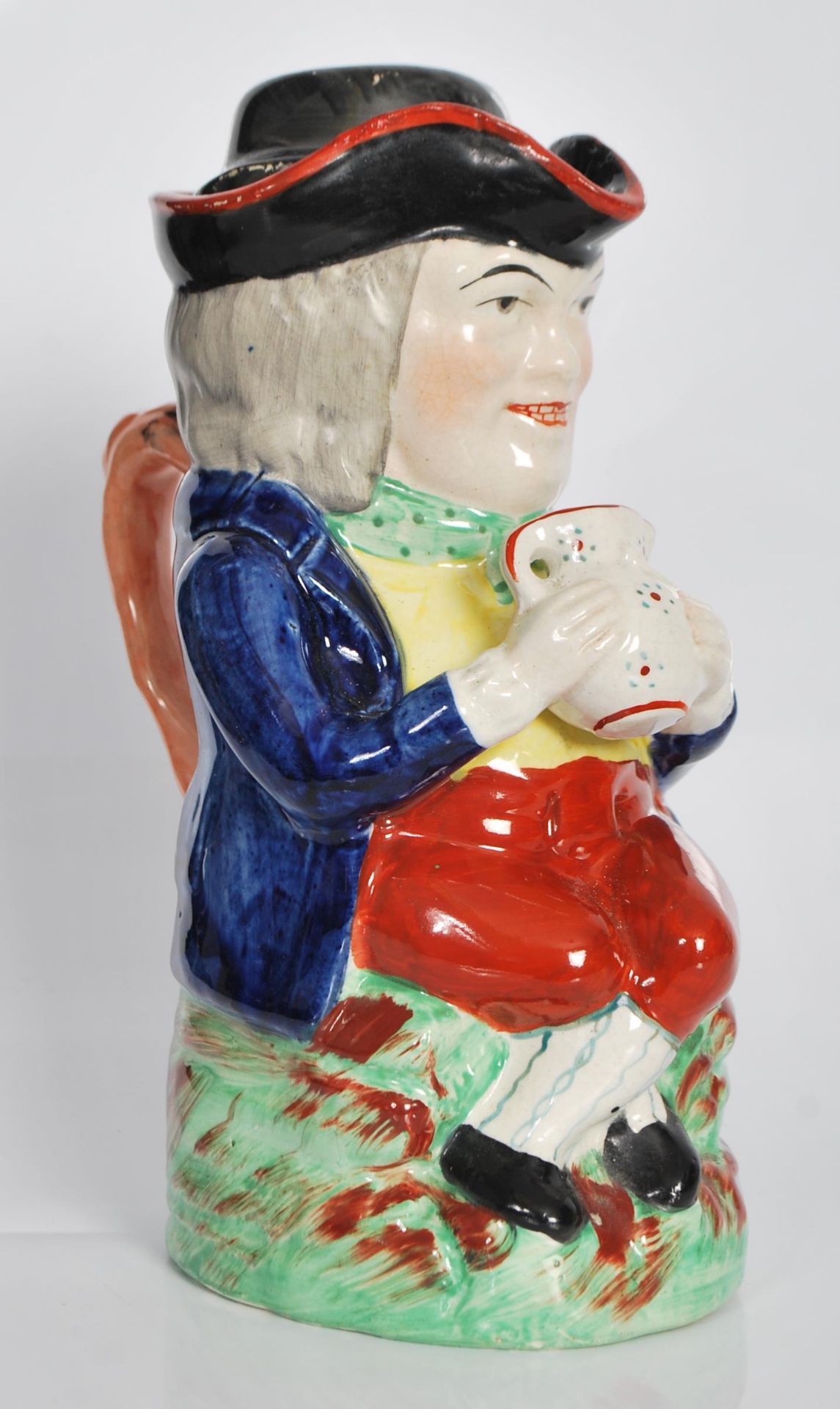 A early 19th Century Staffordshire lidded Toby fillpot jug, the gentleman being dressed in a