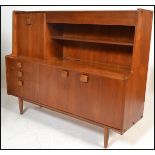 A mid century Danish inspired teak wood sideboard / highboard credenza being raised on tapering legs