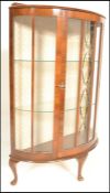A 1940's bow front - demi lune Queen Anne walnut small proportions display cabinet. Raised on