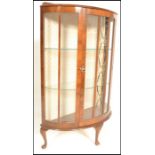 A 1940's bow front - demi lune Queen Anne walnut small proportions display cabinet. Raised on