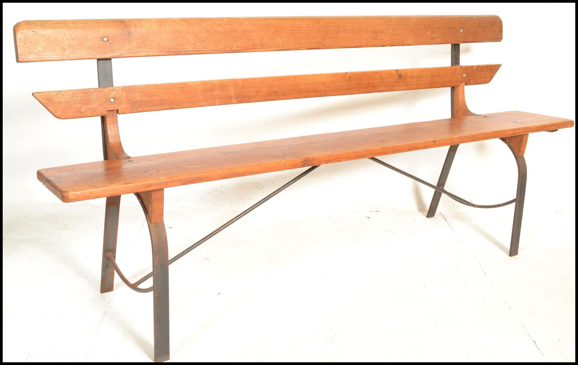 A 20th Century Victorian style pine station bench, raised on upright metal supports with plank