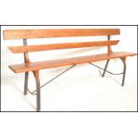 A 20th Century Victorian style pine station bench, raised on upright metal supports with plank