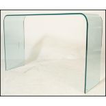 A 20th Century designer contemporary design arched glass console hall table of simple form.