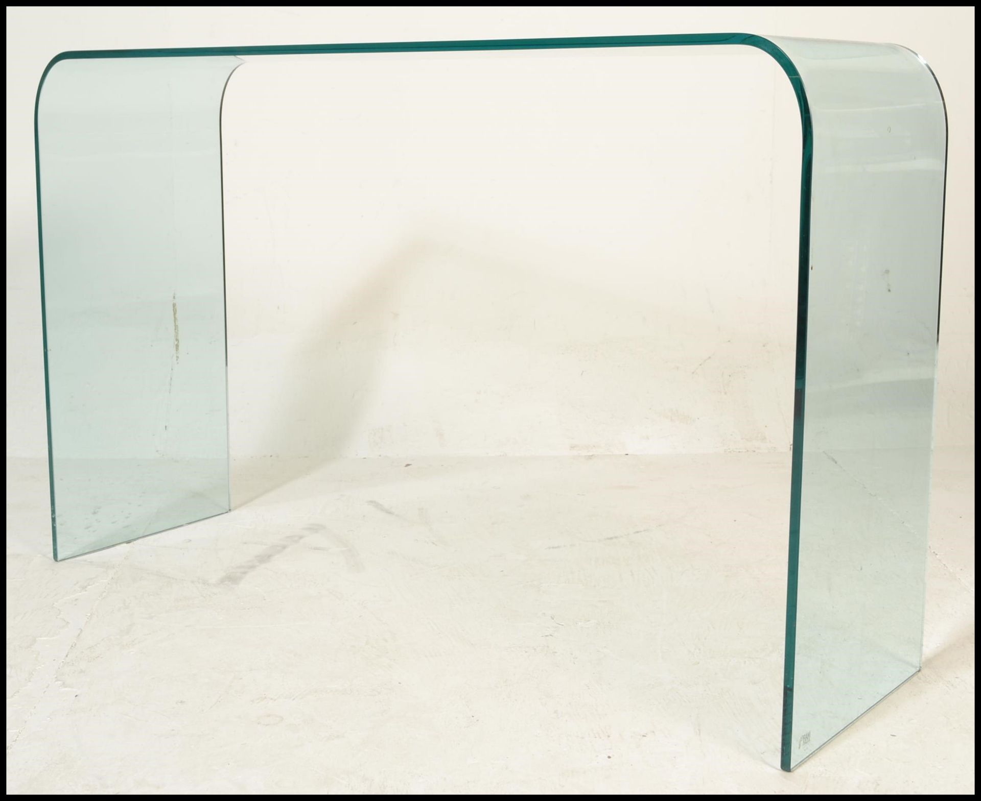 A 20th Century designer contemporary design arched glass console hall table of simple form.