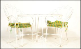 A 20th Century metal garden table and two chairs, the chairs having scroll fan backrests raised on