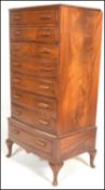 A 20th Century Art Deco Queen Anne bow front walnut tallboy chest of drawers being raised on
