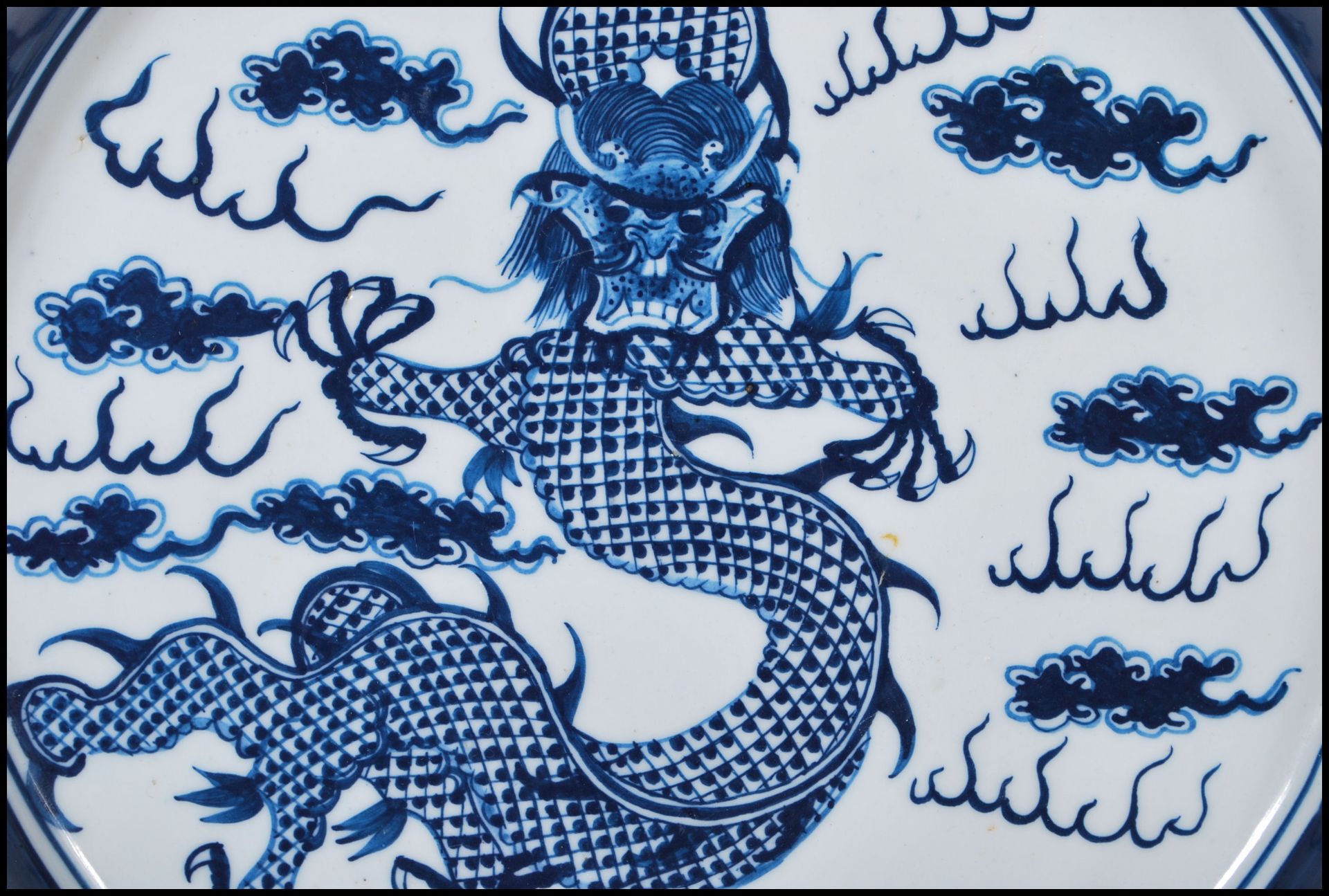 A 19th Century Chinese ceramic plate being hand painted in blue depicting a five toed dragon to - Bild 3 aus 6