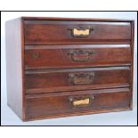 An early 20th century mahogany desk top filing cabinet having flared top over 4 drawers with brass