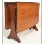 A 1970's teak wood Danish influenced G-Plan drop leaf dining table raised on shaped supports with