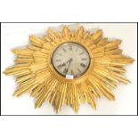 A vintage large 20th Century Art Deco style sunburst starburst rising sun wall clock having a gilt